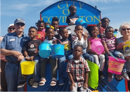 city of covington employees with dozens of children during an Easter egg hunt