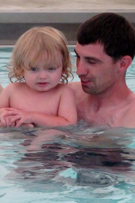 a man and toddler girl in a swimming pool