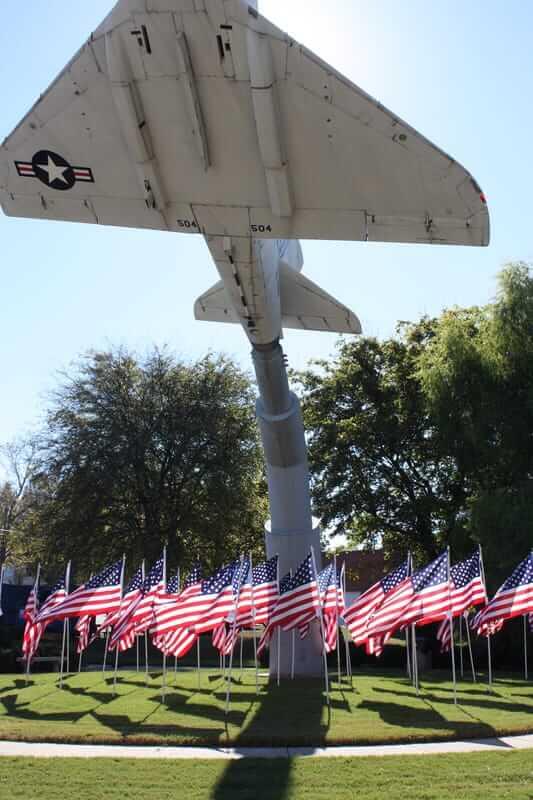 a static display of a fighter jet and several American flags