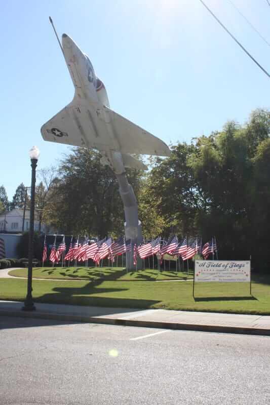 a static display of a fighter jet and several American flags