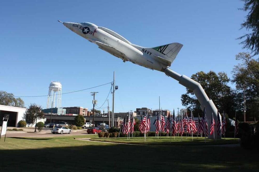 a static display of a fighter jet and several American flags