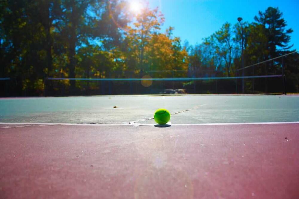 a tennis ball sitting on a clay surface court