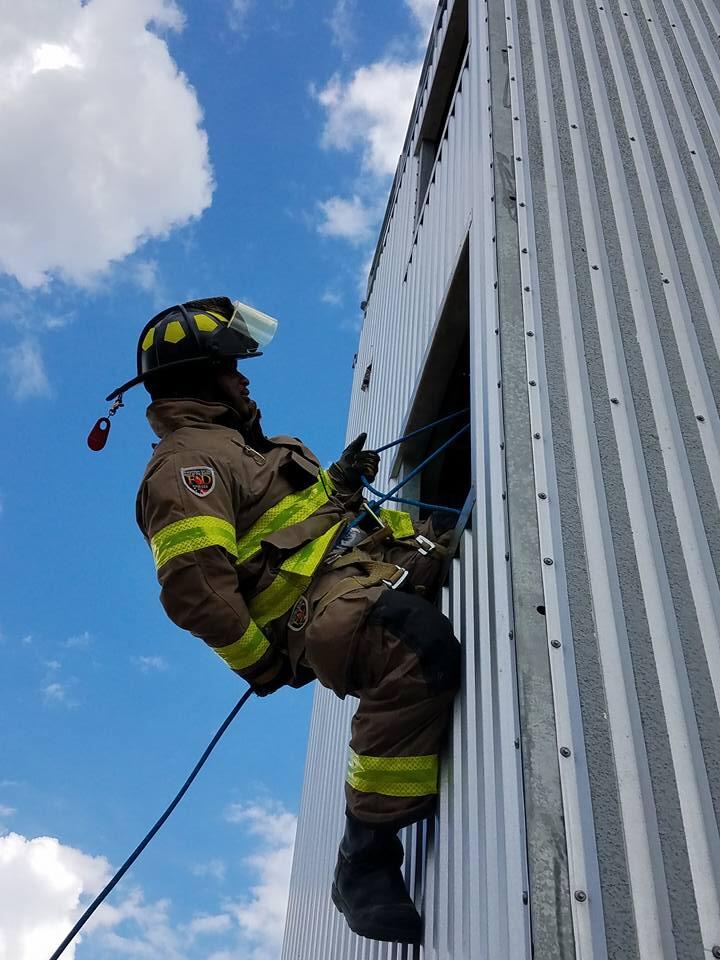 a fireman repelling from a building