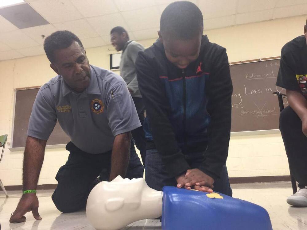 covington fire department members and students practicing cpr on a dummy
