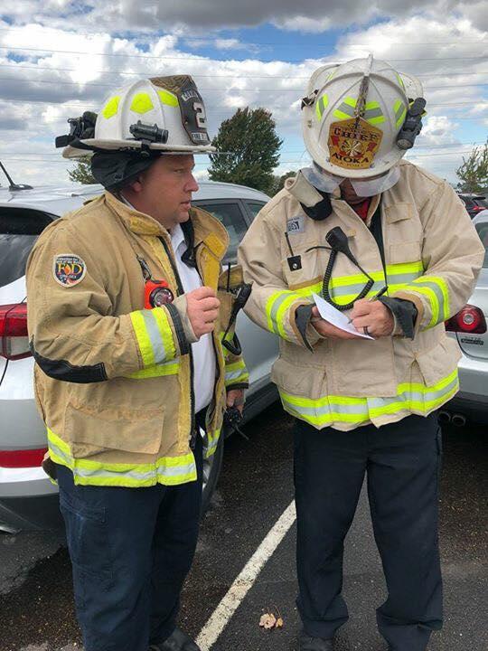 two covington fire department members in full gear talking