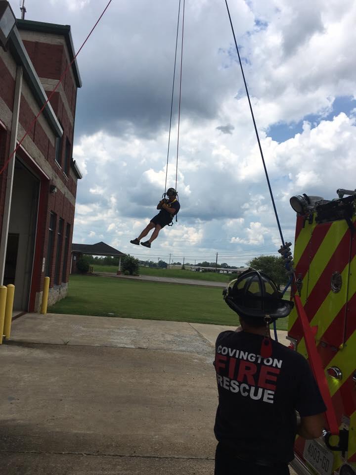 covington fire department member repelling from a rope