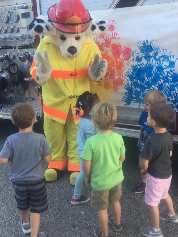 sparky the fire dog mascot visiting with young students