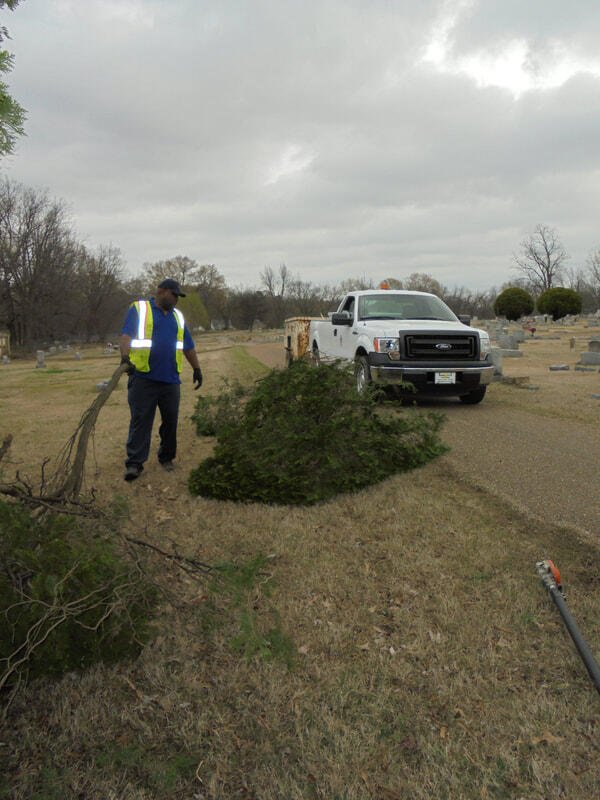 Covington street department employee picking up limbs