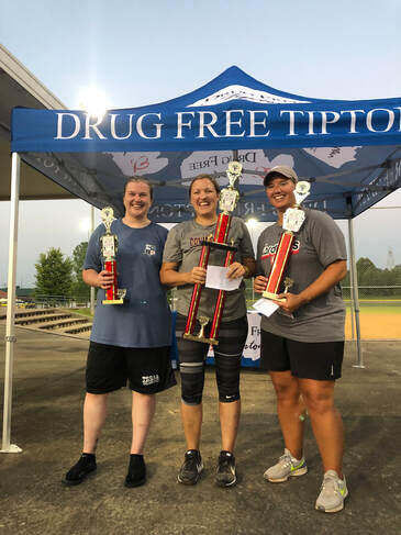 three ladies holding trophies