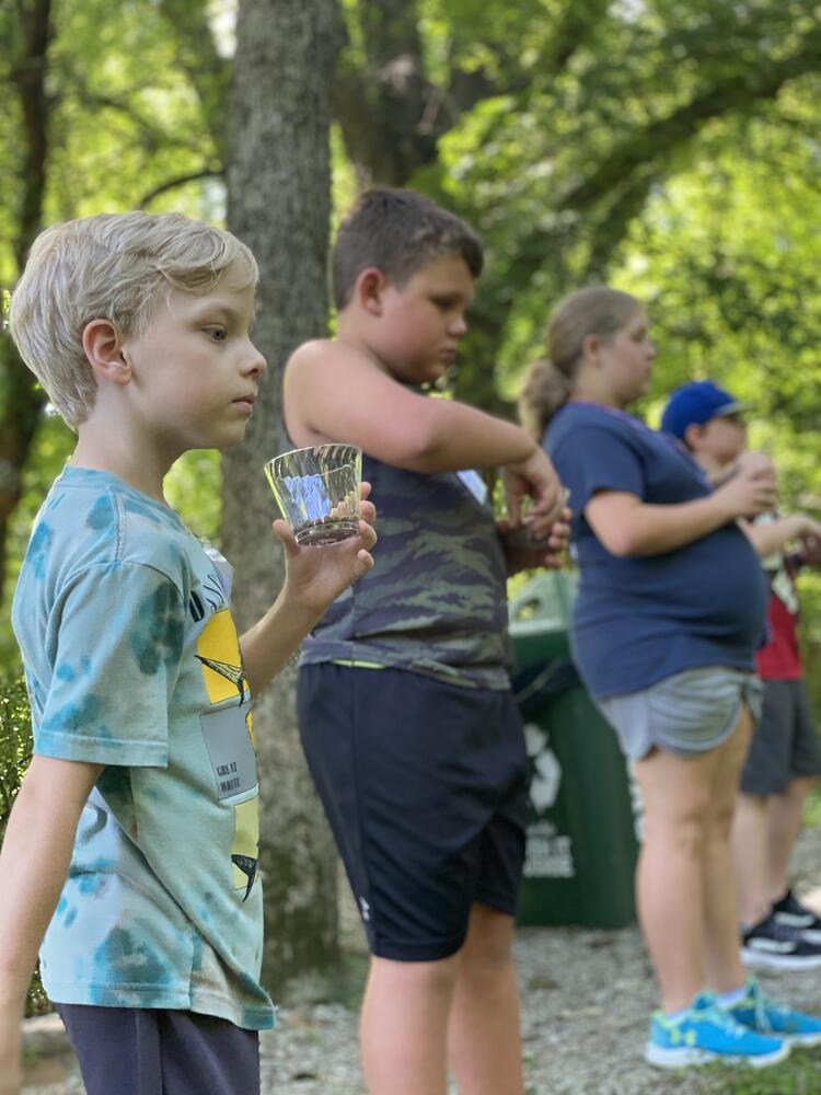 children preparing to throw turtle food into pond