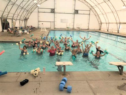 a group of water aerobics participants in a swimming pool