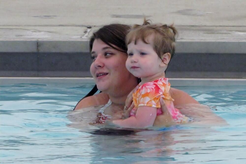 a woman and toddler girl in a swimming pool