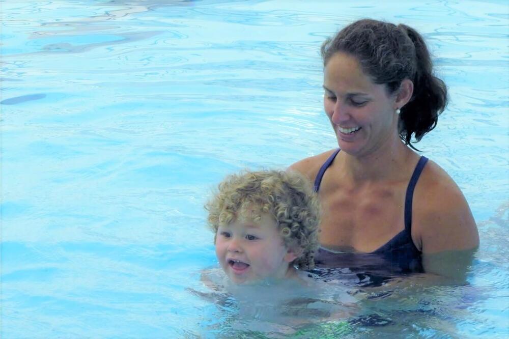 a woman and toddler boy in a swimming pool
