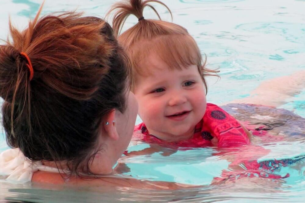 a woman and toddler girl in a swimming pool